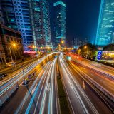 Photo by Peng LIU: Timelapse photography of vehicle on concrete road near in high rise building during nighttime